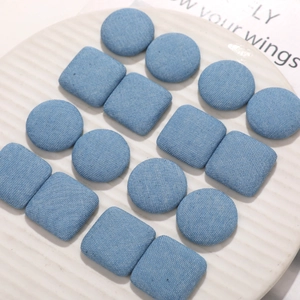 Set of round and square light blue denim fabric buttons with diagonal twill texture