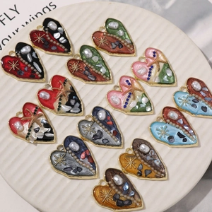 Ciondoli a cuore assortiti con stelle marine e perle in una ciotola decorativa