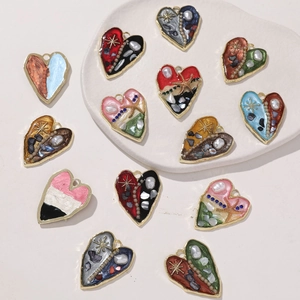 Dettaglio macro di ciondoli a cuore in lega colorata con perle e resina per gioielli DIY