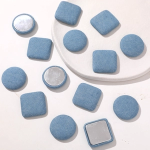 Macro detail of round and square light blue denim fabric buttons for DIY accessories