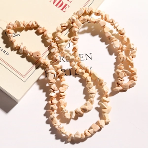 Close-up of irregular cream-colored natural stone chip beads on a vintage book