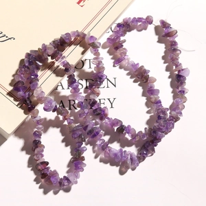 Detailed macro view of irregular natural purple amethyst stone chips for DIY jewelry making