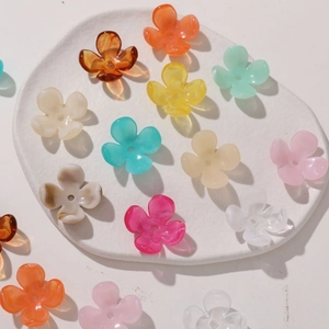 Macro detail of assorted colorful acrylic five-petal flower beads for DIY jewelry making