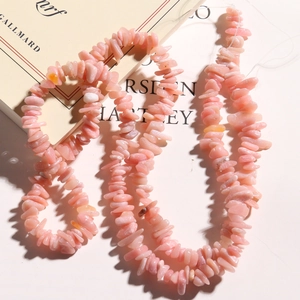 Macro view of irregular pink opal stone beads for DIY jewelry making on art book