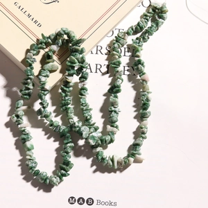 Irregular green natural stone beads on a book for DIY jewelry making accessories