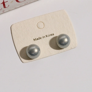 Detail of 12mm grey gradient faux pearl stud earrings on Korean retail card display