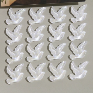 Détail de 16 breloques pigeons en résine nacrée blanche pour la création de bijoux