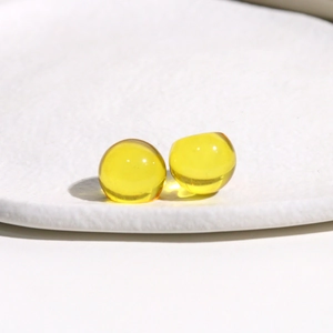 Detailed macro view of two polished 14mm yellow transparent resin round cabochons