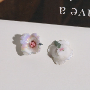 Detailansicht des irisierenden lila Keramikblumen-Zubehörs mit rosa Staubblatt und Rückseite