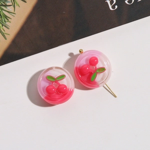 Close-up of sweet resin cherry stud earrings with gold metal posts and round cherry patterns