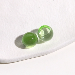 Macro shot of 14mm light green translucent jelly resin round cabochons on white tray