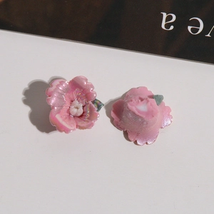 Makroaufnahme von rosa perlmuttfarbenen Keramikblumen mit weißen Staubgefäßen für DIY
