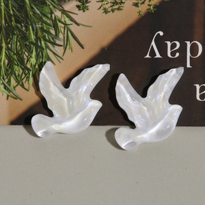 Détail macro de breloques hirondelles en résine irisées avec paillettes pour bijoux DIY