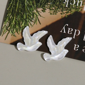Vue détaillée des breloques oiseaux en résine irisée avec finition nacrée pour bijoux DIY