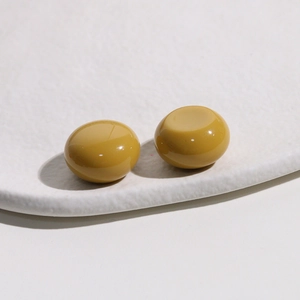 Detailed macro view of mustard yellow resin cabochon beads for DIY jewelry accessories