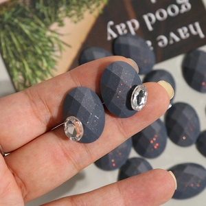 Oval dark grey resin charm with glitter facets and sparkling rhinestone accent