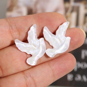 Détail macro de breloques hirondelles en résine nacrée pour boucles d'oreilles et bijoux DIY