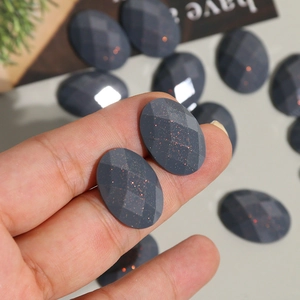 Macro detail of oval glitter resin cabochon with grey faceted surface for DIY jewelry