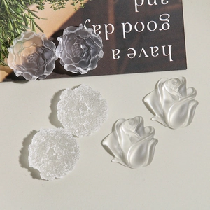 Close-up of matte translucent resin flower charms including roses and peonies