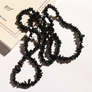 Macro view of natural irregular black stone chips necklace with polished obsidian textures