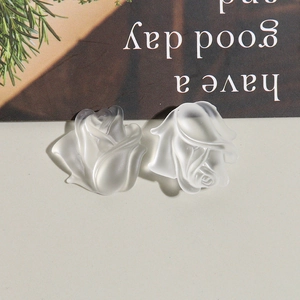 Close-up of matte translucent white resin rose flower charms for DIY jewelry and accessories