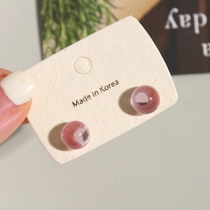 Pink translucent 10mm jelly resin round studs on textured display card with a bokeh background