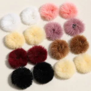 Flat lay of colorful 4cm soft faux fur pompoms for DIY jewelry and accessory making