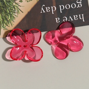 Macro detail of translucent red and pink acrylic four-petal flower beads for DIY jewelry