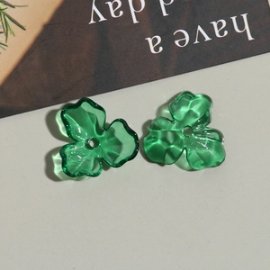Vue macro de deux perles trèfle transparentes vertes pour la création de bijoux DIY