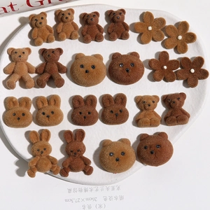 Makroaufnahme von beflockten braunen Teddybären und Blumenanhängern für DIY-Schmuck