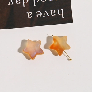 Macro detail of star-shaped frosted resin bead with orange and white marble texture