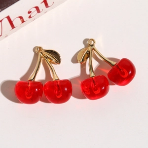 Macro detail of cherry pendants with translucent red resin and gold leaf hooks for DIY