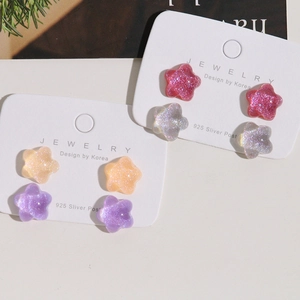 Close-up of sparkling star-shaped resin stud earrings with 925 silver needles