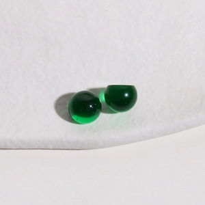 Macro shot of two dark green 10mm translucent resin half-round beads for DIY jewelry