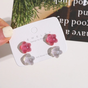 Detailed view of glitter star resin stud earrings with S925 silver needles on card