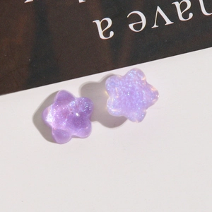 Detailed macro view of purple star-shaped glitter resin charms for DIY earring making