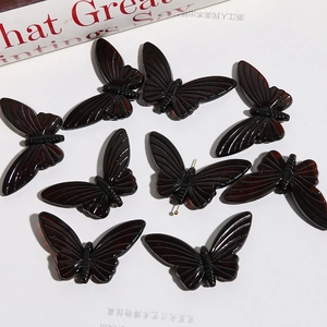 Detailed view of translucent amber butterfly beads with delicate textures for DIY jewelry