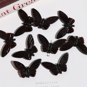 Macro detail of dark translucent butterfly acrylic beads for DIY jewelry and crafts