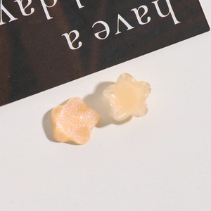 Macro detail of star-shaped resin earring studs with sparkling pink glitter finish