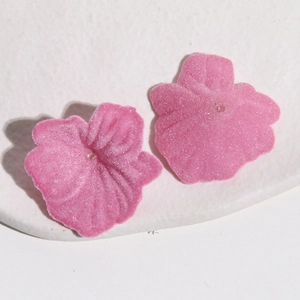 Détail macro de breloques fleurs roses floquées avec texture velours pour bijoux DIY