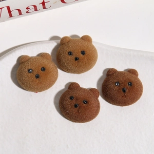 Nahaufnahme von vier braunen beflockten Teddybären auf einer strukturierten Keramikplatte