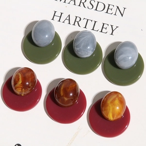 Detailed macro view of Morandi-colored geometric resin earrings with marble and amber textures