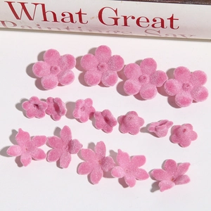 Macro detail of pink flocked lily flower charms for DIY jewelry and earring making