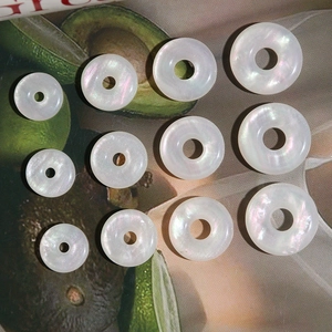 Close-up of circular faux mother-of-pearl opal charms for DIY jewelry making