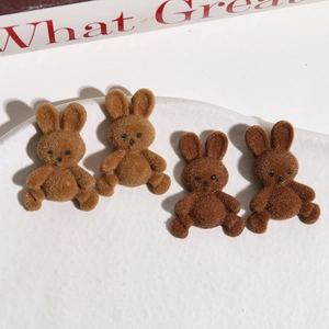 Nahaufnahme von vier braunen beflockten Hasenfiguren für DIY-Ohrringe auf weißer Keramik