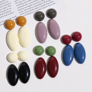 Flat lay of colorful oval resin drop earrings in diverse Morandi tones on a magazine