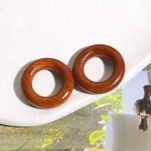 Detailed close-up of polished round wooden rings featuring natural wood grain texture
