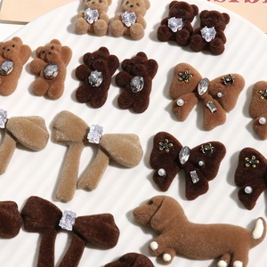 Macro shot of flocked bear and puppy charms with rhinestones on a white ceramic plate