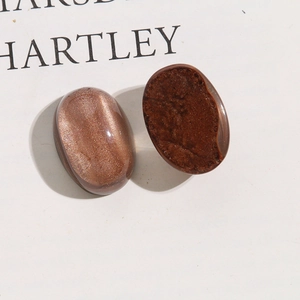 Dettaglio di cabochon ovali in resina con trama di sabbia dorata per gioielli fai da te