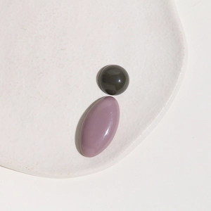 Close-up of glossy Morandi-colored resin oval and round flatback charms for DIY jewelry